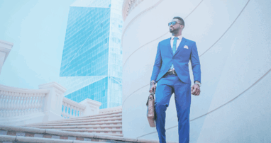 A business person with a breifcase walks down a set of outdoor stairs