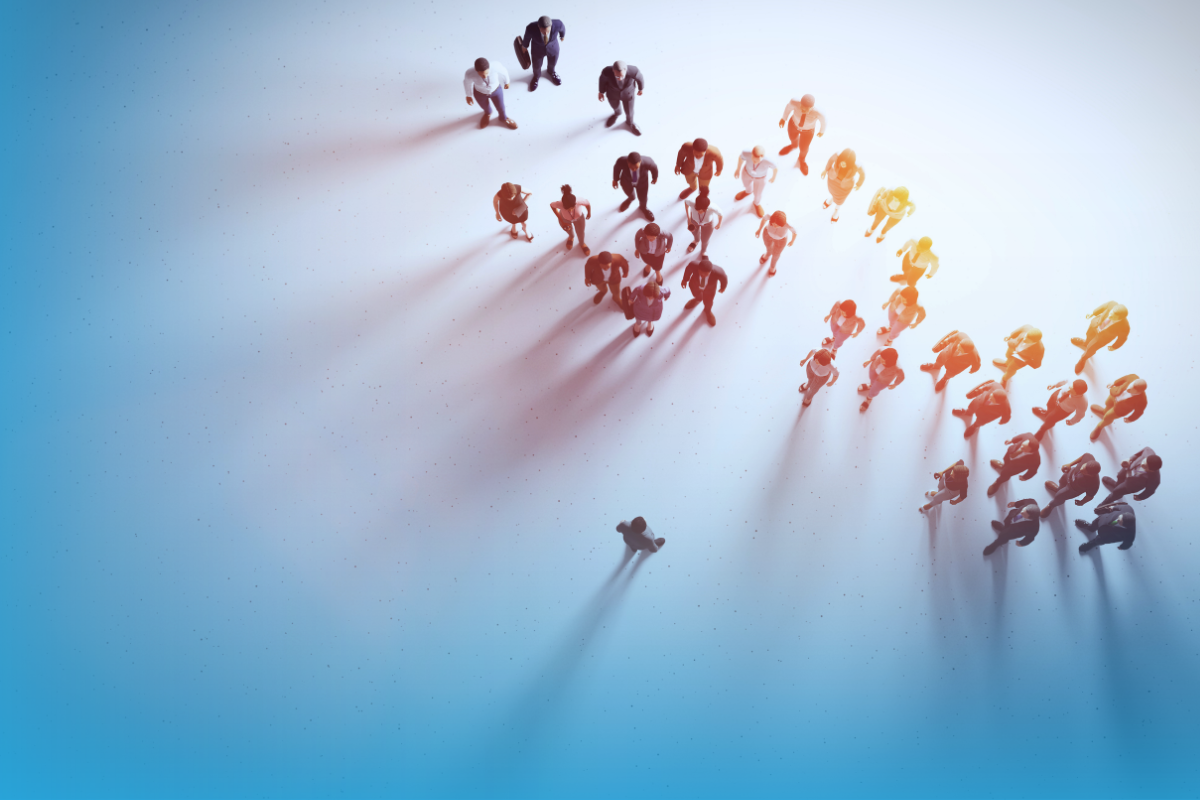 An overhead shot of a person standing apart from a crowd