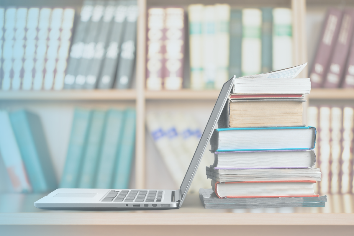 An open laptop against a stack of books